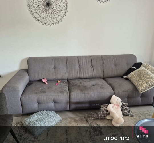 ספה עם כתמים, כריות וצעצועים על הרצפה